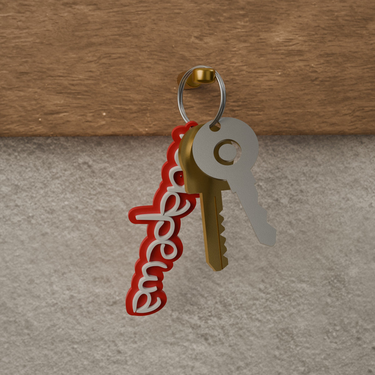 Red and white Ndapewa name keyring on a key ring with two keys, hanging from a hook