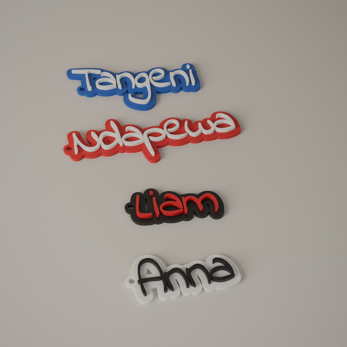 Four name keyrings in blue, red, black and white with different letter colours